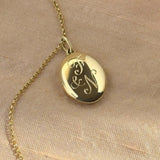 Solid yellow gold heirloom locket with traditional hand engraving of loved ones initials