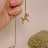 yellow gold horse charm shown on a chain 